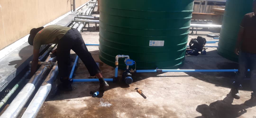 Plumbers connecting pipework to the storage tanks